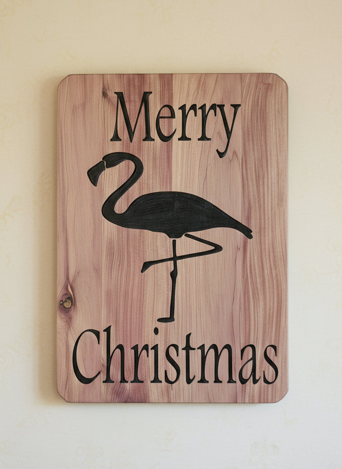 Wooden sign with a flamingo design and 'Merry Christmas' text, surrounded by festive decorations.